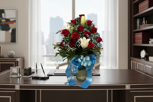 Red and white lily flower arrangement with roses greenery and blue accent flowers for Houston flower delivery