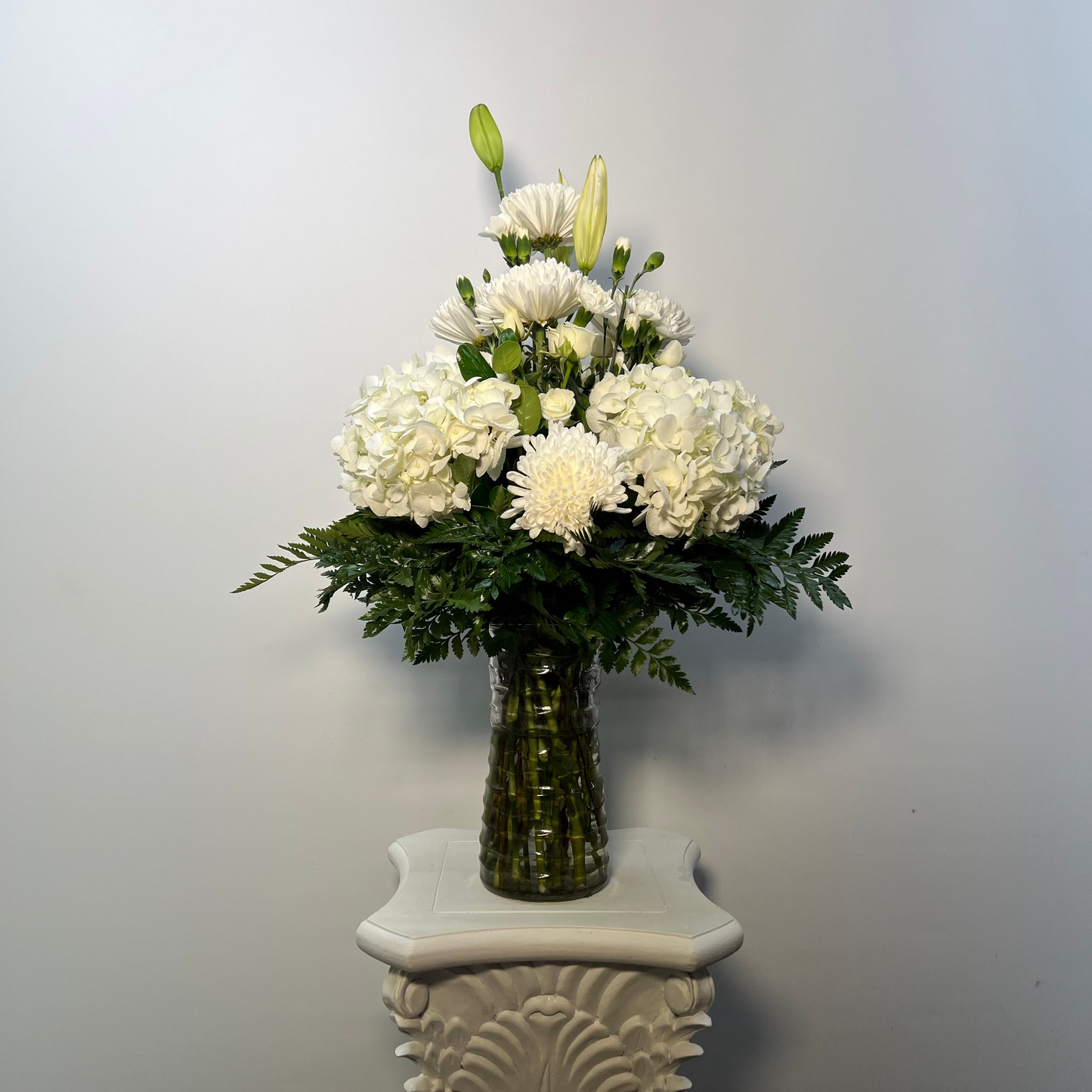 White sympathy vase arrangement with hydrangeas lilies mums and greenery for Houston flower delivery