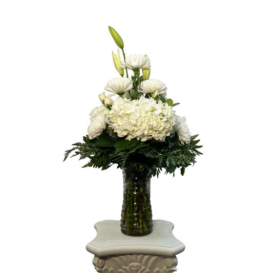 All white vase arrangement with hydrangeas lilies mums spray roses and fresh greenery by Houston florist