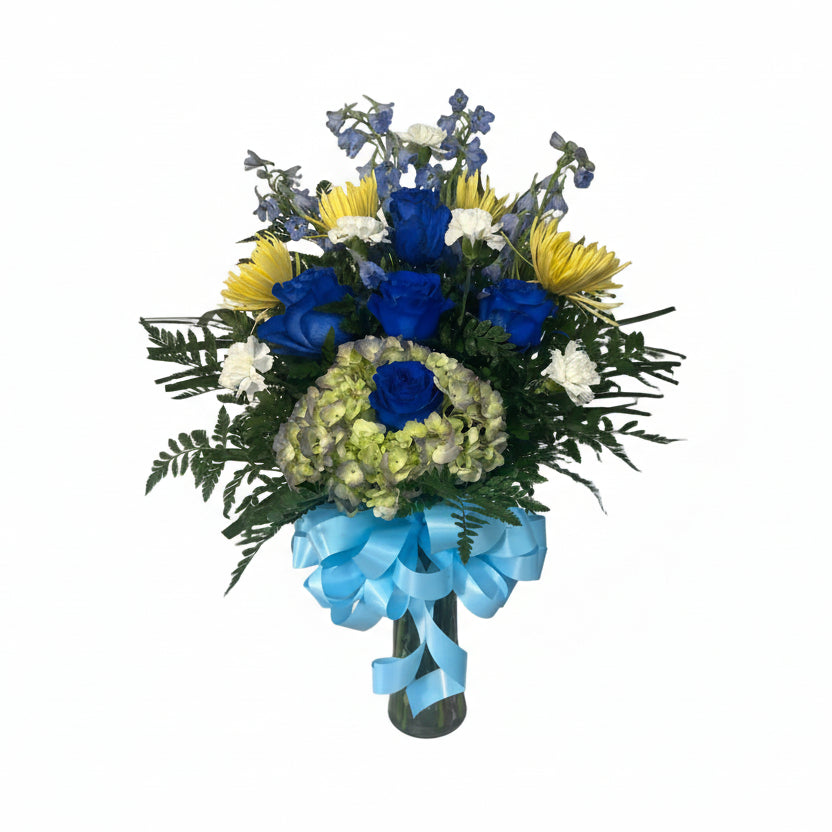 Blue and yellow floral vase arrangement with blue roses delphinium hydrangea and fresh greenery by Houston florist