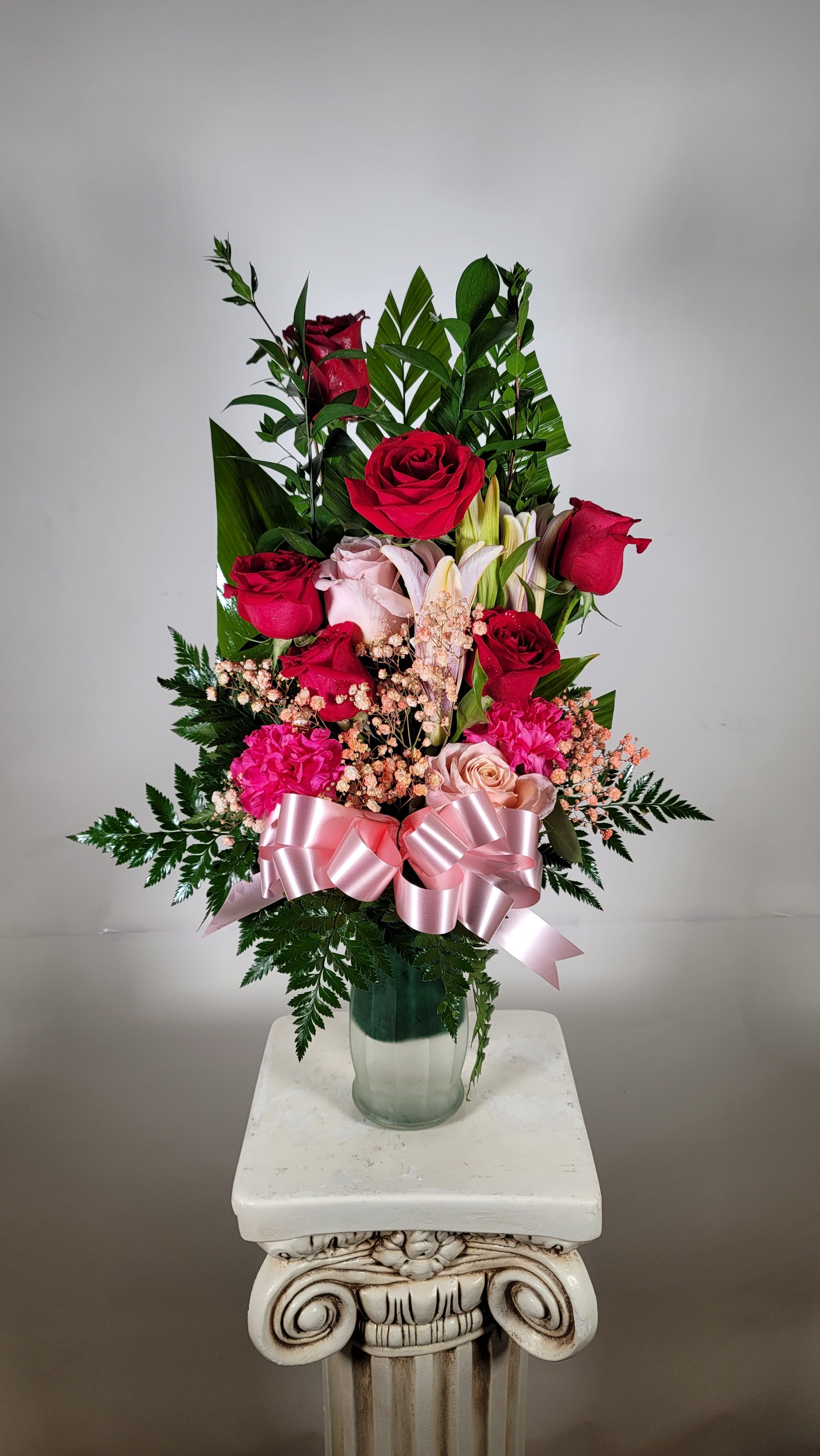 Elegant pink and red vase arrangement with roses lilies and tinted filler flowers in Houston