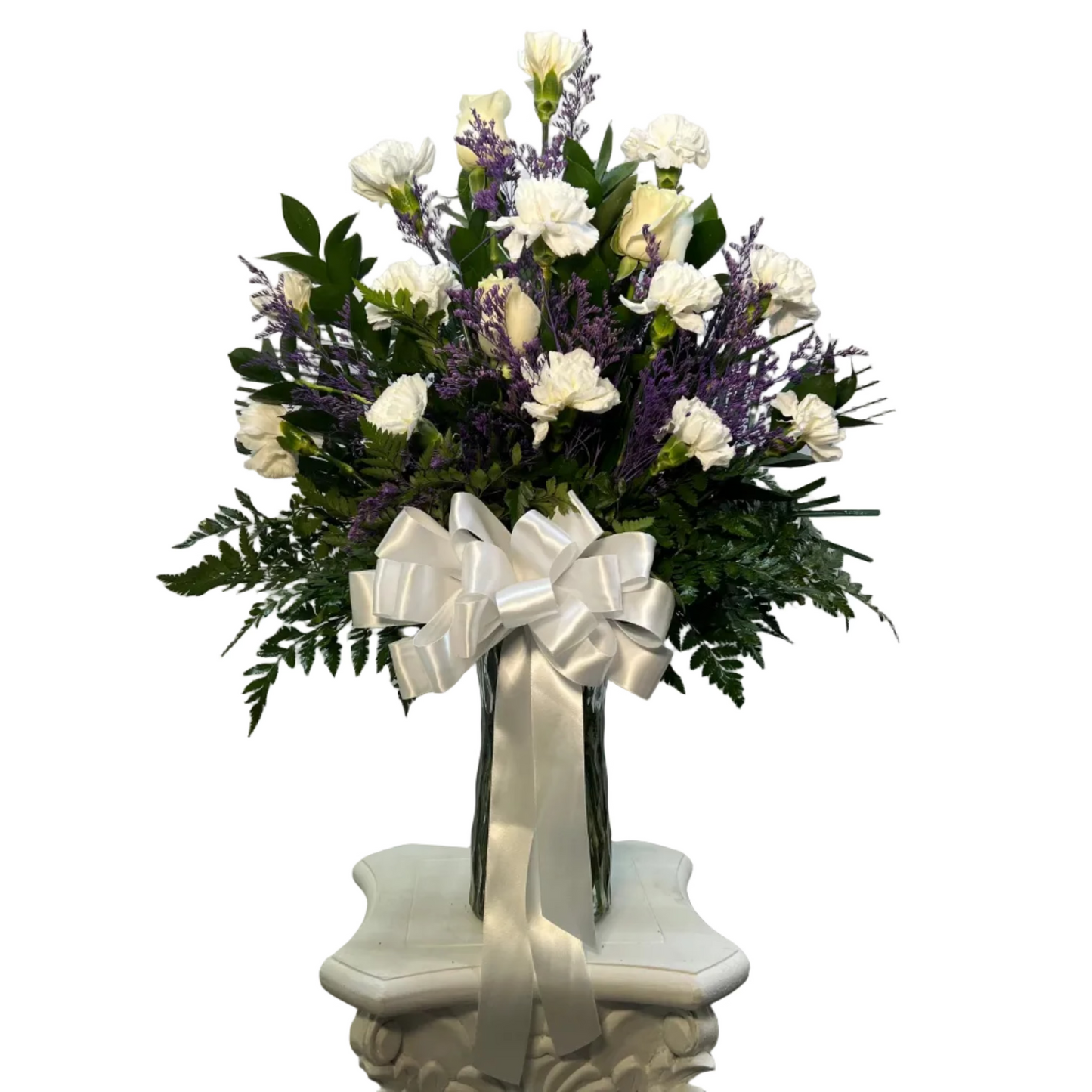 Elegant white rose and carnation flower arrangement in a glass vase with lavender accents and greenery