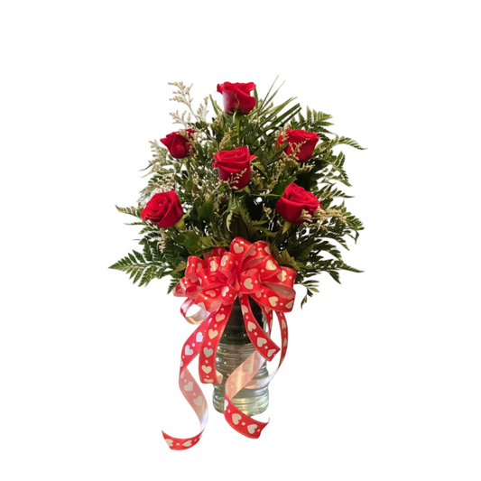 Half dozen red rose arrangement in vase with fresh greenery and heart ribbon by Houston florist