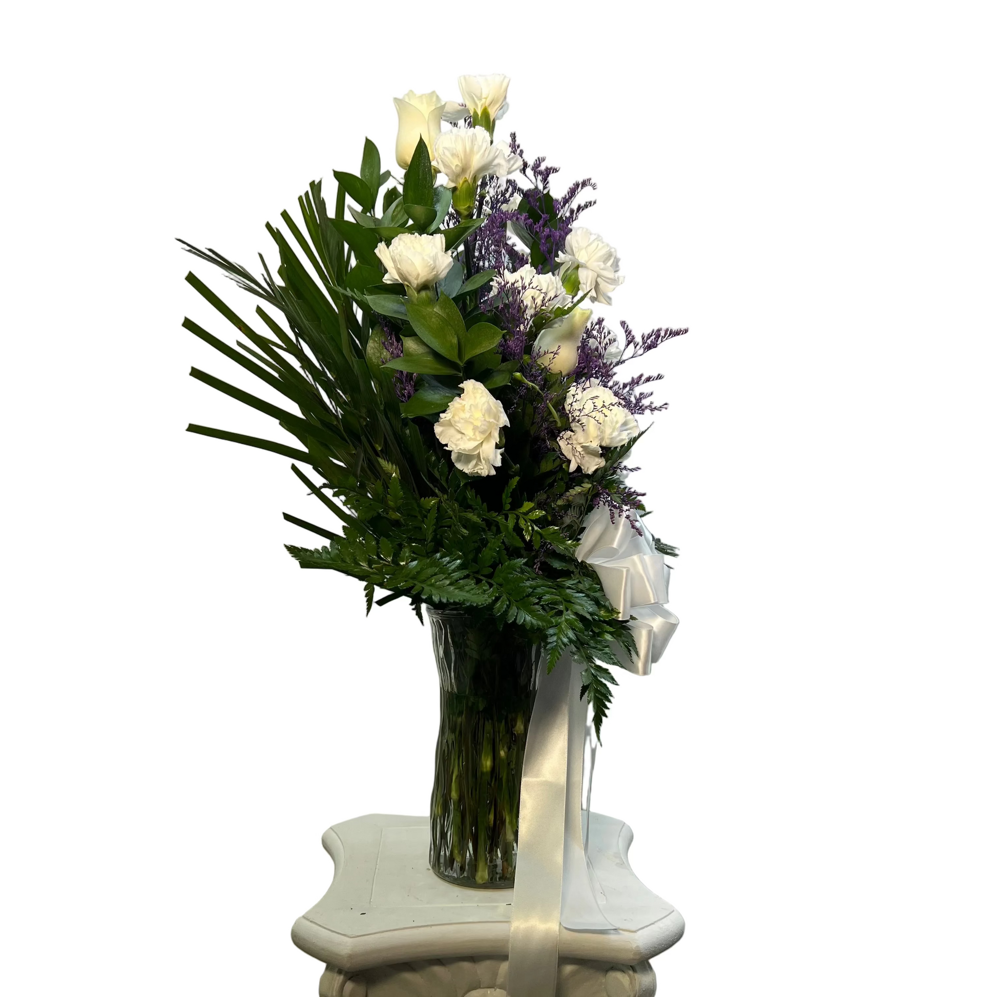 Bouquet of flowers in a vase on a decorative pedestal against a plain background