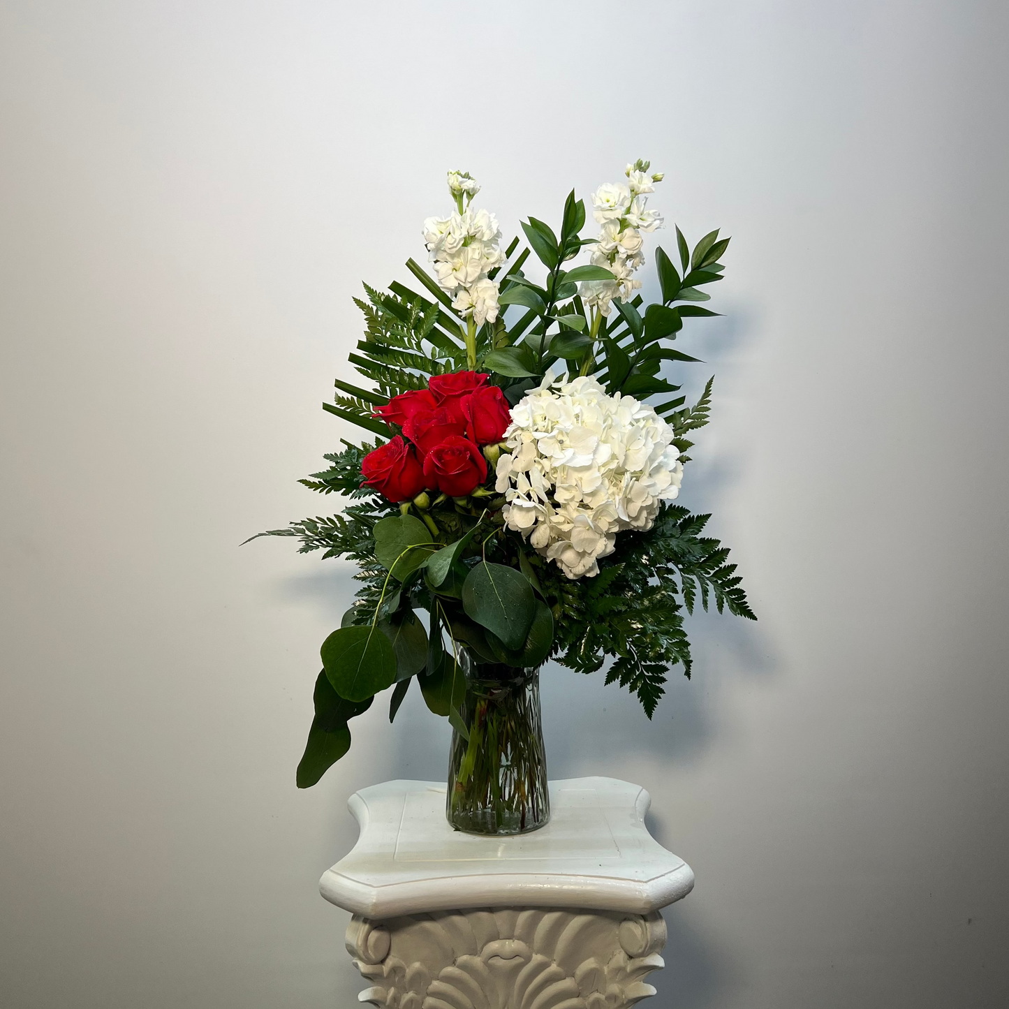 Red rose and white hydrangea vase arrangement with fresh greenery by Houston florist