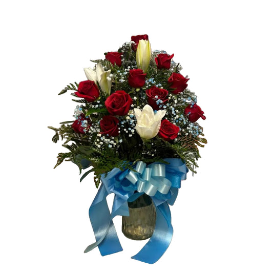 Red rose and white lily vase arrangement with blue accent filler flowers and ribbon by Houston florist