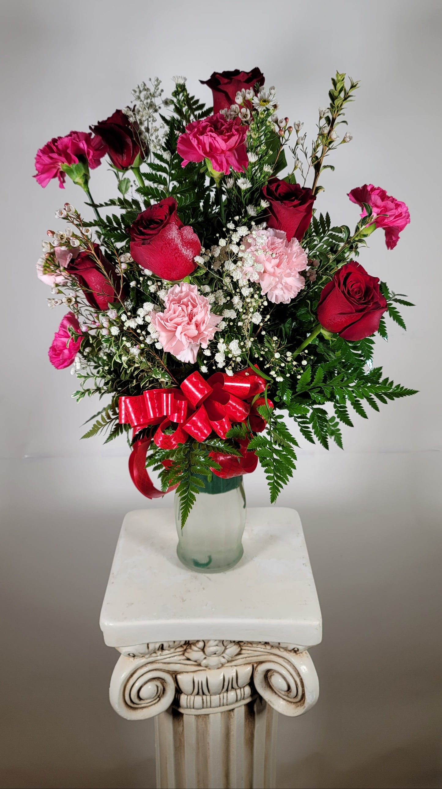 Romantic red and pink flower arrangement with roses carnations and fresh greenery for Houston delivery