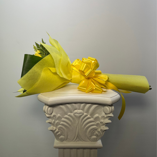 Side view of small yellow flower bouquet wrapped for delivery by Houston florist
